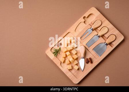 Gewürfelter Cheddar, Gouda oder Parmesankäse auf einem Schneidebrett. Gewürfelter Käse Stockfoto
