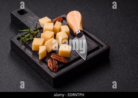 Gewürfelter Cheddar, Gouda oder Parmesankäse auf einem Schneidebrett. Gewürfelter Käse Stockfoto