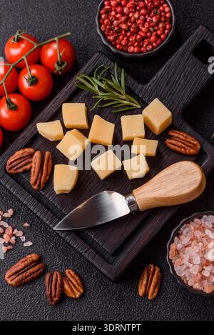 Gewürfelter Cheddar, Gouda oder Parmesankäse auf einem Schneidebrett. Gewürfelter Käse Stockfoto