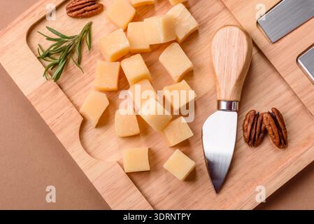 Gewürfelter Cheddar, Gouda oder Parmesankäse auf einem Schneidebrett. Gewürfelter Käse Stockfoto