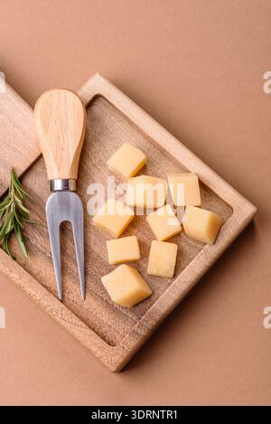 Gewürfelter Cheddar, Gouda oder Parmesankäse auf einem Schneidebrett. Gewürfelter Käse Stockfoto