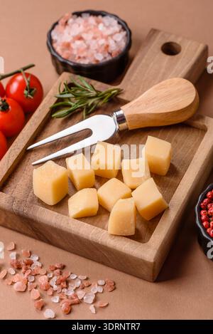 Gewürfelter Cheddar, Gouda oder Parmesankäse auf einem Schneidebrett. Gewürfelter Käse Stockfoto