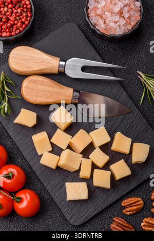 Gewürfelter Cheddar, Gouda oder Parmesankäse auf einem Schneidebrett. Gewürfelter Käse Stockfoto