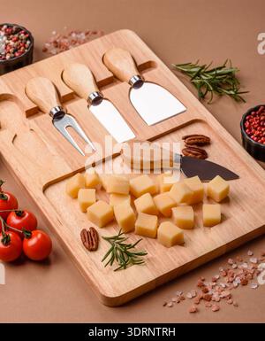 Gewürfelter Cheddar, Gouda oder Parmesankäse auf einem Schneidebrett. Gewürfelter Käse Stockfoto