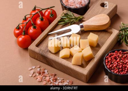 Gewürfelter Cheddar, Gouda oder Parmesankäse auf einem Schneidebrett. Gewürfelter Käse Stockfoto