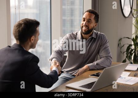 Ein afroamerikanischer Unternehmer schüttelt die Hand mit einem Geschäftsexperten Stockfoto