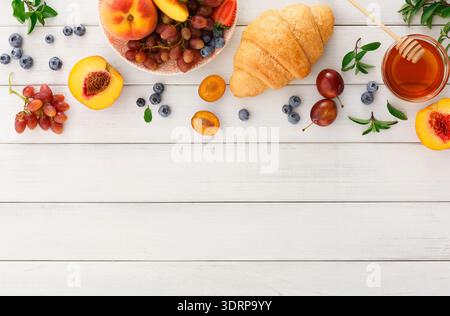 Frisches Obst und Gebäck auf einem Holztisch mit Honig auf der Seite Stockfoto