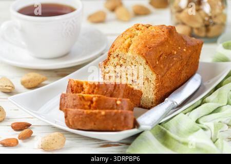 In Scheiben geschnittener Kuchen mit Mandeln auf dem Schneidebrett. Hausgemachter Kuchen mit Nüssen und Honig. Leckerer Snack zum Tee Stockfoto