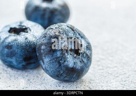 Frische Heidelbeeren mit Wassertropfen auf einer hellen Oberfläche in Nahaufnahme. . Antioxidans, organisches Superfood. Das Konzept von gesund und di Stockfoto