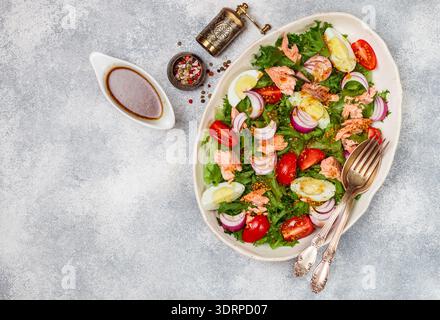 Frischer Delikatessensalat (Forelle) mit Salat, Tomaten, Eiern und roten Zwiebeln mit Senfdressing und Olivenöl im Wei Stockfoto