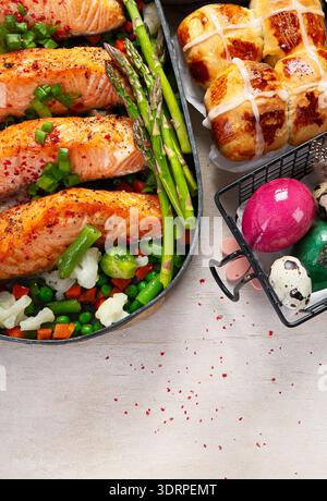 Im Ofen gebratener Lachs mit grünen Bohnen und Spargel zum Osterbrunch oder Abendessen auf hellem Hintergrund. Draufsicht. Stockfoto