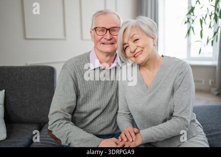 Älteres erwachsenes Ehepaar umarmt zu Hause. Alter Mann und Frau im mittleren Alter, die sich mit Zärtlichkeit umarmen, lieben es, süße Bindungen zu genießen Stockfoto