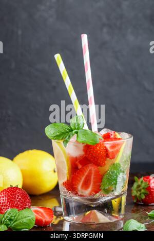 Sommer eine erfrischende Limonade. Trinken mit Zitrone, Erdbeere, Minze, Basilikum und Eis. Detox. Mineralwasser. Selektiver Fokus Stockfoto