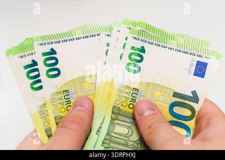 Nahaufnahme eines Mannes, der Euro-Bargeld isoliert auf weiß hält. Investitions- und Vermögenskonzept. Stockfoto