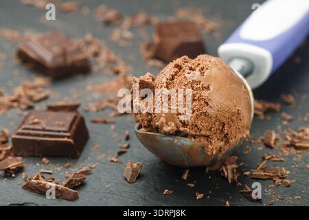 Sommerdessert. Hausgemachtes Schokoladen-Karamell-Eis in einem Löffel. Selektiver Fokus Stockfoto