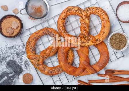 Brezel. Frisch gebackene Brezeln mit Zucker, Mohn, Zimt und Kümmel. Köstliches hausgemachtes süßes und salziges Gebäck und Essen Stockfoto
