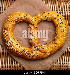 Frisch gebackene hausgemachte Brezel mit schwarz-weißen Sesamsamen. Deutsche (bayerische) Biervorspeise. Traditionelles herzhaftes Gebäck. Stockfoto