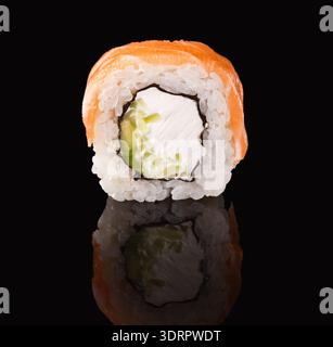 In der Mitte geschnittene Sushi-Rolle mit Füllung und Reis auf dunklem Hintergrund Stockfoto