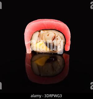 Mosaik von Sushi-Stücken mit verschiedenen Zutaten auf einer schwarzen Oberfläche Stockfoto
