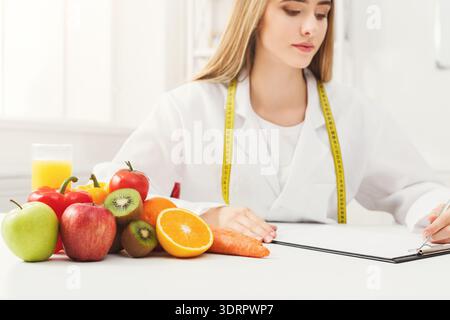 Sammlung von Obst und Gemüse auf dem Tisch mit Frau Mess- und Schreibnotizen Stockfoto