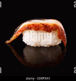 Sammlung von Sushi-Stücken auf schwarzem Hintergrund, die Vielfalt und Textur zeigen Stockfoto