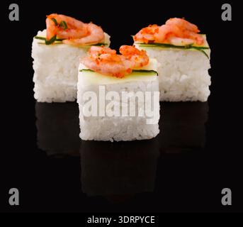Unzählige Sushi-Stücke in einer ordentlichen Collage auf einer dunklen Oberfläche angeordnet Stockfoto