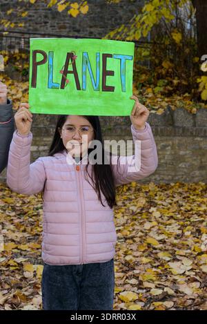 Piacenza, Italien - 3. Februar 2022 Mädchen mit einem handgefertigten grünen Schild, auf dem DER PLANET steht, das Maßnahmen gegen den Klimawandel und die Umweltverschmutzung fordert Stockfoto