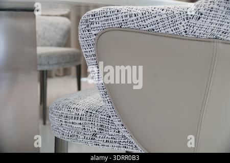 Stuhl mit weiß-schwarz gemustertem Sitz und Rücken. Der Stuhl ist aus Leder und hat ein modernes Design Stockfoto