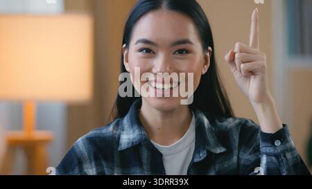 Porträt Asiatische koreanische Frau denkt, Idee zu haben, kreative intelligente Frau, die Zeigefinger zu Hause hebt nachdenkliche Dame erinnert sich an Lösung entscheiden Problem Stockfoto
