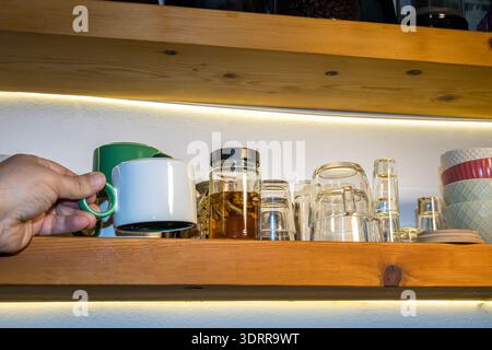 Händige Kaffeetasse auf hölzernem Küchenregal Stockfoto