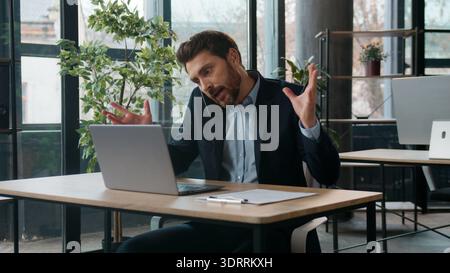 Geschäftiger kaukasischer Geschäftsmann im Büro Tippen Laptop sprechen Handy Streit professioneller männlicher Manager Multitasking diskutieren Handy-Streit Stockfoto