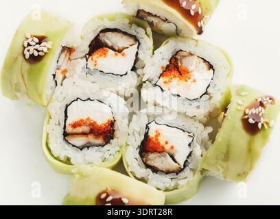 Sammlung von Sushi-Rollen, die in einem Kreismuster auf einer weißen Oberfläche angeordnet sind Stockfoto