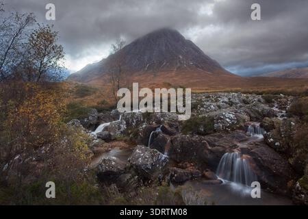 Glen Etive Wasserfälle und felsiger Bach unterhalb eines dramatischen Berges unter Sturmwolken in den schottischen Highlands im Herbst. Stockfoto