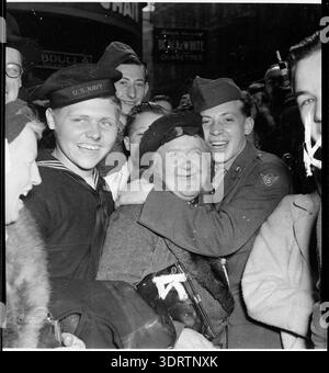 7. Mai 1945. Amerikanischer Seemann und Soldat umarmt die englische Frau im Piccadilly Circus, um Deutschlands bedingungslose Kapitulation im Zweiten Weltkrieg zu feiern, die am 8. Mai 1945, VE Day, abgeschlossen werden soll. Stockfoto