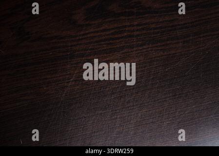 Dunkler Hintergrund mit Holzstruktur und sichtbaren Kratzern und Makrodetails mit Holzmaserung für Innenarchitektur und Möbelrestaurierungskonzepte Stockfoto