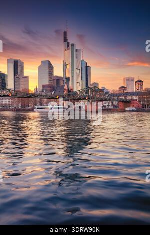 Frankfurt am Main, Deutschland. Stadtbild von Frankfurt am Main, Deutschland mit Spiegelbild der Skyline des Main bei schönem Sonnenuntergang. Stockfoto