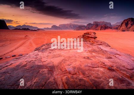 Sonnenuntergang in der malerischen Wüste Wadi Rum mit herrlicher Berglandschaft und rotem Sand, Jordanien. Stockfoto