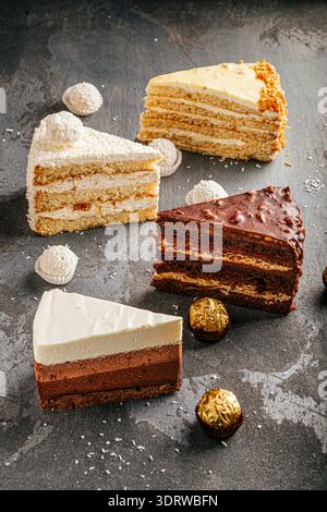 Gemischte Kuchen auf dunklem Steintisch Stockfoto