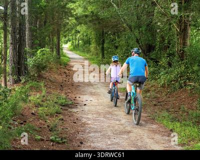 Raleigh, North Carolina, USA. Ein Vater und eine Tochter fahren Mountainbikes auf einem bewaldeten Pfad im Williamson Preserve. Stockfoto