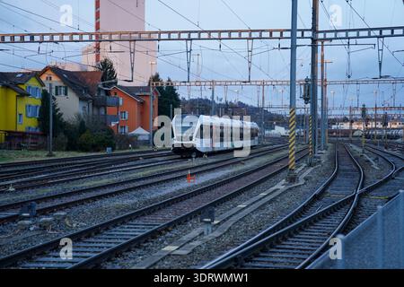 Wil SG, Schweiz, Europa, Bahnhof Wil, Thurbo, Regionalzug, S-Bahn, Gleisanlagen, Weichen, Oberleitungen, Bahninfrastruktur, Schienenverkehr, öffentlicher Verkehr, Pendlerverkehr, Nahverkehr, Verkehrsknotenpunkt, Stadtquartier, Wohnhäuser, Abenddämmerung, nachhaltige Mobilität, Verkehrswende, SBB-Netz, Transportwesen, Reportagefotografie *** Wil SG , Schweiz, Europa, Bahnhof Wil, Thurbo, Regionalzug, S-Bahn, Gleisanlagen, Weichen, Freileitungen, Eisenbahninfrastruktur, Eisenbahnverkehr, öffentlicher Verkehr, Pendlerverkehr, Nahverkehr, Verkehrsknotenpunkt, Stadtviertel, Wohngebäude Stockfoto