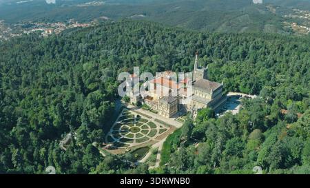 Blick aus der Vogelperspektive auf den Bussaco-Palast in Luso Portugal, umgeben von üppig grünen Waldbergen, einem Garten mit historischem architektonischem Kulturerbe Stockfoto