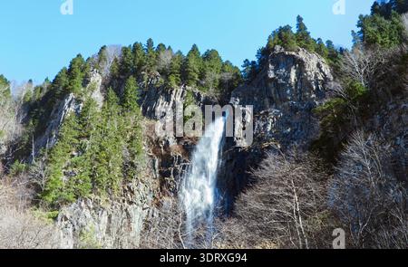 Panoramablick auf einen Wasserfall, der von High Cliffs mit Evergreen Forest stürzt. Eine Weitwinkelaufnahme eines mächtigen Wasserfalls, der durch den Jag fließt Stockfoto