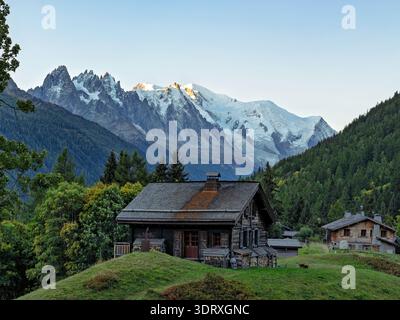 Haute-Savoie, Frankreich - 19. September 2025: Panoramablick auf traditionelle Almhütten in Tre-le-Champ mit dem schneebedeckten Mont Blanc-Massiv Stockfoto