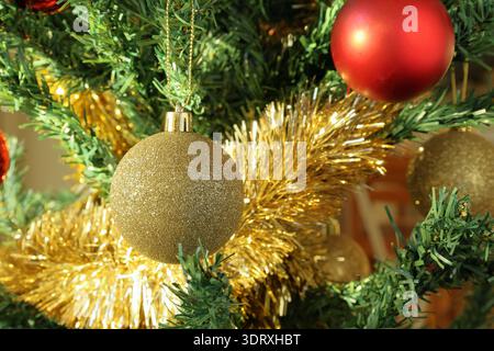 Weihnachtsbaumschmuck. Glänzende goldene und rote Farben. Nahaufnahme des Fotos. Stockfoto