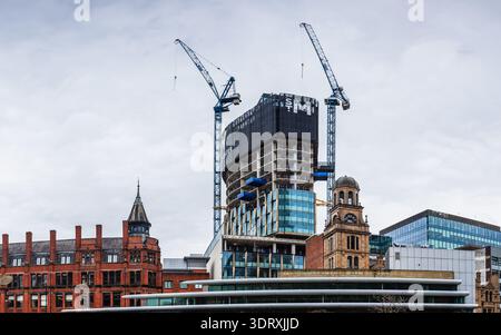 Breiter Panoramablick, der die Mischung aus historischer Architektur und neuen Wolkenkratzerbauten mit Kränen in Manchester am 18. Februar 2026 zeigt. Stockfoto