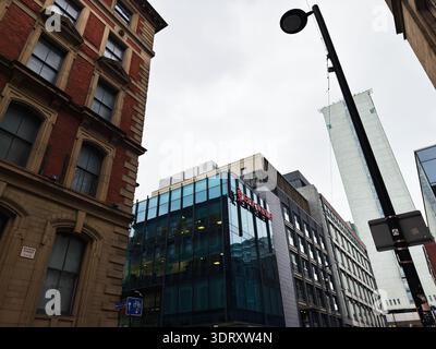 Manchester, Großbritannien - 29. Januar 2026: Blick auf die George Street in Manchester mit einem Bürogebäude der Britannia English School mit Glasfassade und alten Backsteinen Stockfoto