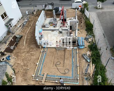 Von oben nach unten auf eine Wohnbaustelle mit neu errichtetem Betonfundament und teilweise fertiggestellten Kellerwänden. Aushubarbeiten Stockfoto