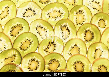 Sammlung geschnittener Kiwis, die in einem Mosaikmuster auf einer flachen Oberfläche angeordnet sind Stockfoto
