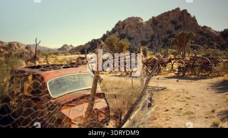 Eine alte, rostige Karosserie befindet sich im Sommer hinter einem Drahtzaun auf der historischen Keys Ranch im Joshua Tree National Park, Kalifornien. Stockfoto