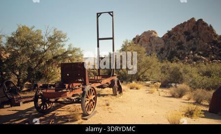 Das rostige Metallgehäuse eines alten Fahrzeugs steht senkrecht auf dem Sand auf der Keys Ranch im Joshua Tree National Park in der Sonne. Stockfoto